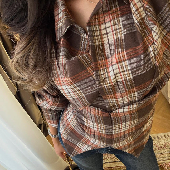 A woman wears a brown plaid long-sleeve shirt with a turn-down collar and a defined waist.